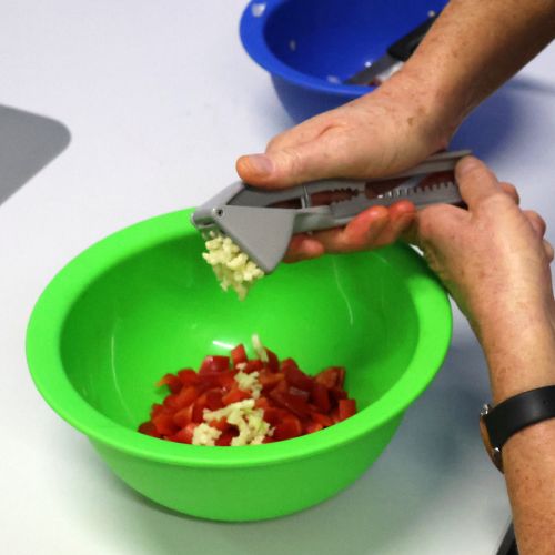 Für die Gemüselasagne wird zu den Paprikastücken frischer Knoblauch gepresst