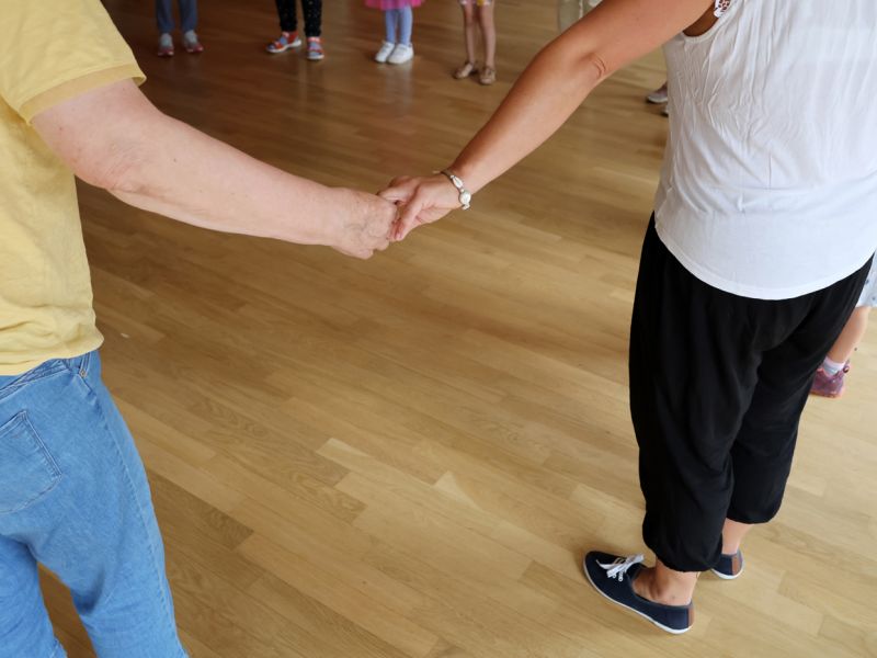 Teilnehmer des Tanz-Workshops fassen sich an den Händen